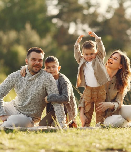 Loving family with two young son playing in summer field